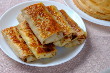 Süzme peynirli ince krepler, bir tüpün içine sarılmış. Pagan Slav bayramı Maslenitsa için şenlikli bir yemek.