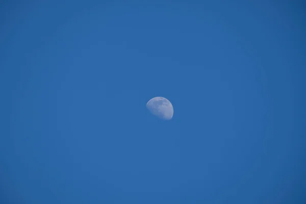 Small moon on a blue background - third quarter