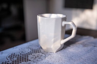 A hexagonal diamond shape mug with an irregular shape in the sunshine
