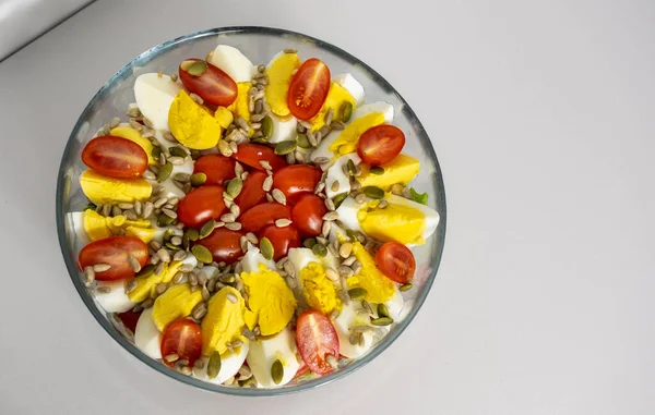 Salad with quartered egg, tomato, lettuce, and grains in a bowl