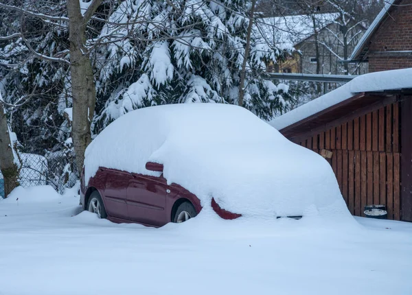 A large snow cap on the car - a car buried by snow powder