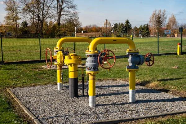 Gas pipes, natural gas transport system. Transmission infrastructure coming from the ground, yellow pipes with valve and flow meter