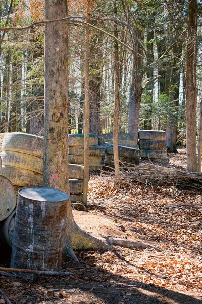 Metal barrels in the forest during the game, cover and shelter in sports on the paintball field, paintballs cover in the arena