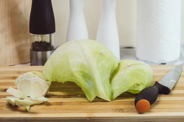Kesme tahtasında lahana yaprakları ve arka planda bir bıçak - mutfak masası