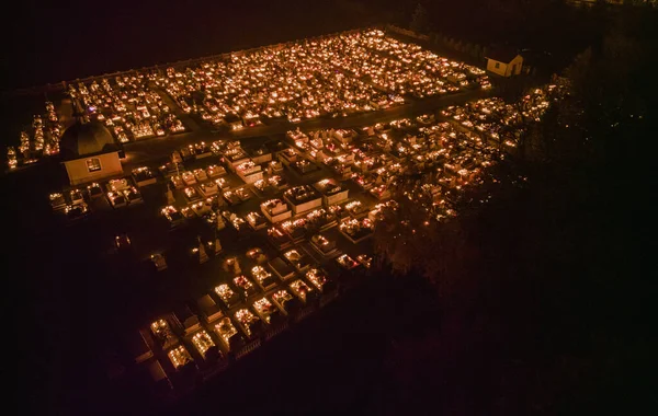 Mezarlıktaki ölüler gününde mumların ışığıyla aydınlatılan mezarlar. Yukarıdan insansız hava aracı görüntüsü.