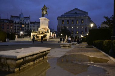 Fountain of the monument of the equestrian statue of Philip IV, stone bench in the foreground and the royal theater in the background, night photography clipart