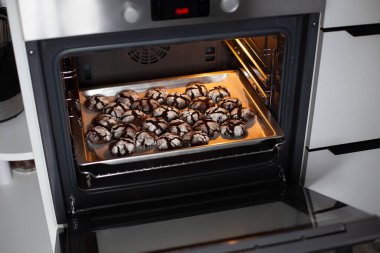 Fırında pişirilmiş pudra şekerli taze çikolata parçacıklı kurabiyeler. Lezzetli ev yapımı pişirme, fırındaki kağıt tepsilerde tatlı..