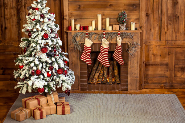 Beautiful holiday decorated home room with Christmas tree, gifts under it and red Christmas socks.