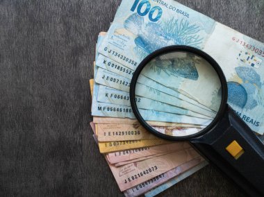 Brezilya para banknotları üzerinde büyüteç. Finans kavramı.