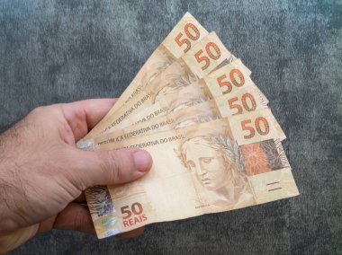 Elle tutulan 50 reais banknot. Brezilya parası..