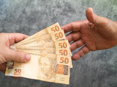 Elle tutulan 50 reais banknot. Brezilya parası..