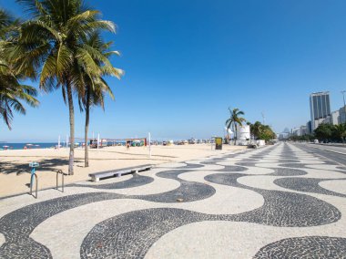 Copacabana Sahili 'ndeki ünlü sahil yürüyüşü ve Rio de Janeiro Brezilya' da mavi gökyüzü olan hindistan cevizi ağaçları..