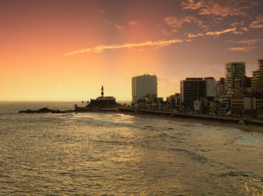 Salvador Bahia 'da Barra sahilinde gün batımında Barra Deniz Feneri arka planda..