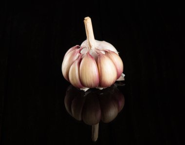 Kapalı sarımsak ampulü siyah arka planda izole edilmiş..