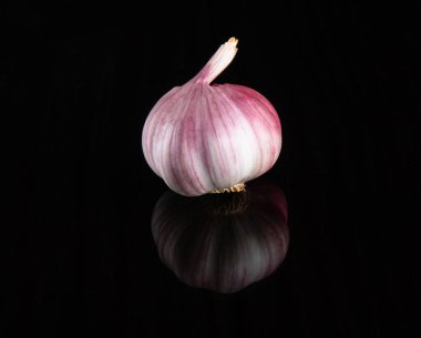 Kapalı sarımsak ampulü siyah arka planda izole edilmiş..