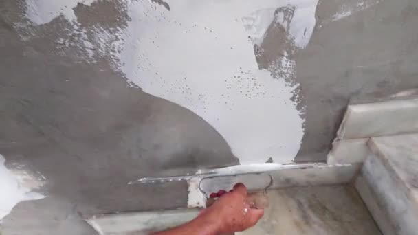 労働者は壁にスタッコの仕上げの層をプラスチック製のタオルで置く — ストック動画