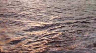 Deniz dalgaları gün ışığında kayaya çarpıyor. Yaz günbatımı deniz manzarası