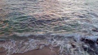 Deniz dalgaları gün ışığında kayaya çarpıyor. Yaz günbatımı deniz manzarası