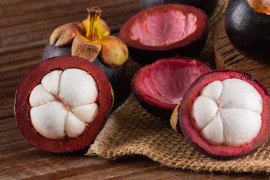 Tahta bir masada kesilmiş taze mangosteen meyvesi..