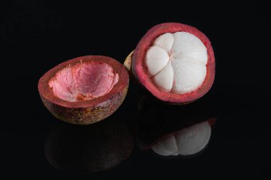 Siyah arka planda kesilmiş taze mangosteen meyvesi..
