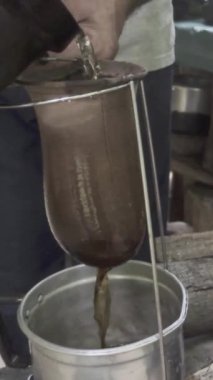 Adam kahve yapıyor. Kumaşa sıcak su koyuyor. Ağır çekimde filtre yapıyor. Dikey video