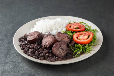 Gri arka planı olan geleneksel Brezilyalı Feijoada tabağı.