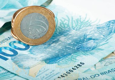 Brezilya parası işte. Brezilya Real para biriminin yakın çekimi, 1 Real madeni para 100 banknotun üzerinde dinleniyor.