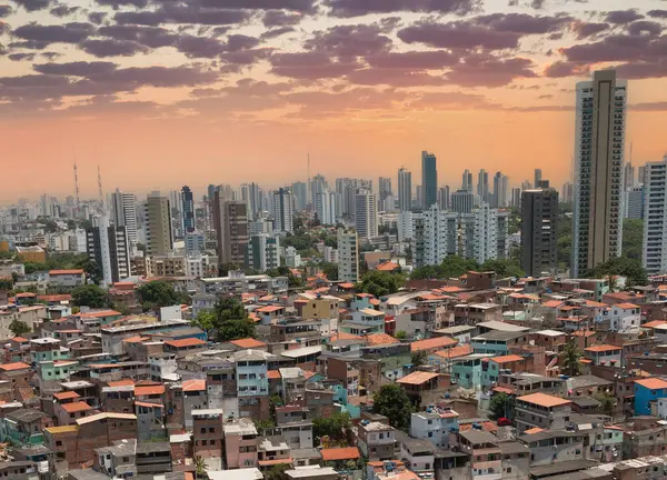 Şehir kontrastı. Günbatımında sosyal eşitsizliği vurgulayan Favela ve modern gökdelenler.
