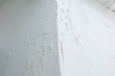 Çatlak ve küflü beyaz duvar köşesi.