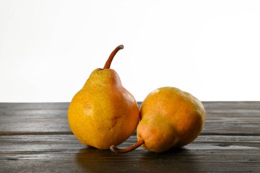 Tahta bir masa ve beyaz arka planda bitkisel koruma tedavisi olmayan iki organik armut.