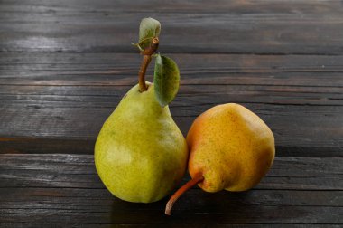 Tahta bir masada bitkisel koruma olmayan iki organik armut..