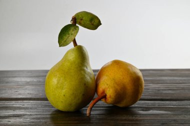 Tahta bir masa ve beyaz arka planda bitkisel koruma tedavisi olmayan iki organik armut..