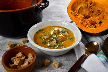 Maydanozlu balkabağı kreması ve seramik kasede servis edilen kızarmış ekmek. 