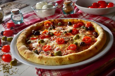 Kiraz domatesli, zeytinli, ançüezli ve kaparili Akdeniz pizzası ahşap fırında pişirilmiş.