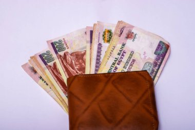 Banknotes on a brown leather wallet, concept of savings, Egyptian 200-pound banknotes
