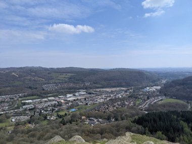 Ağaçlarla dolu bir tepe manzarası berrak mavi gökyüzü.