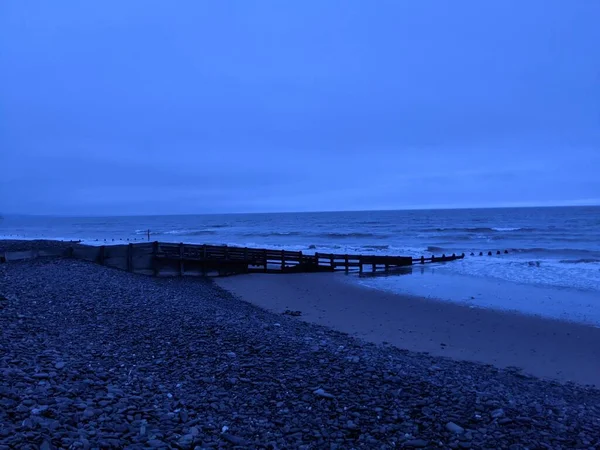夕暮れ時にビーチに波が打ち寄せる静かな海の海岸 — ストック写真
