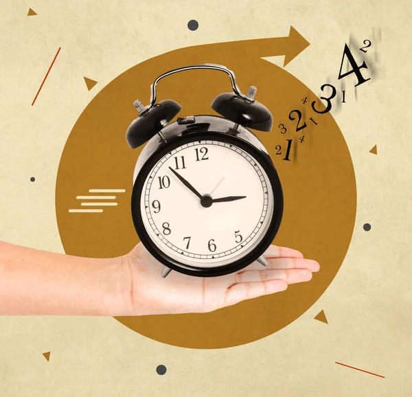 Hand holding a clock with numbers detached in the air, concept of time passing quickly
