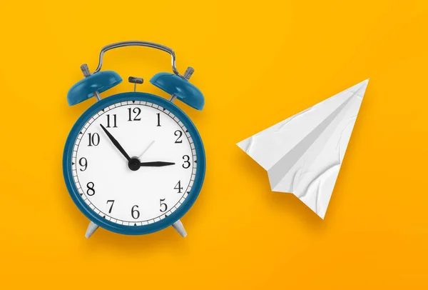Time to travel concept. alarm clock with paper airplane on yellow background