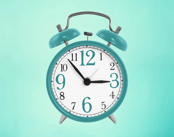 Blue alarm clock with prominent numbers on blue background
