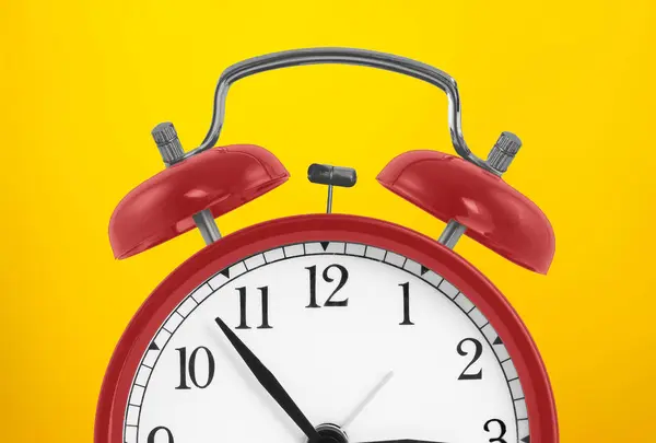 亮黄色背景上的红色老式闹钟 最低限度的创意概念 — 图库照片