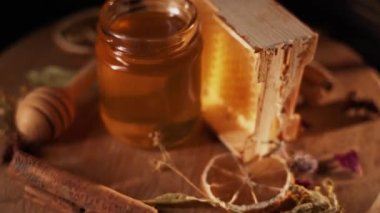 Healthy organic honey in a plate with wooden honey dipper top view on black background. Sweet honey healthy dessert Close up
