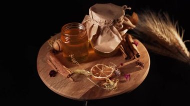 Healthy organic honey in a plate with wooden honey dipper top view on black background. Sweet honey healthy dessert Close up