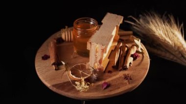 Healthy organic honey in a plate with wooden honey dipper top view on black background. Sweet honey healthy dessert Close up