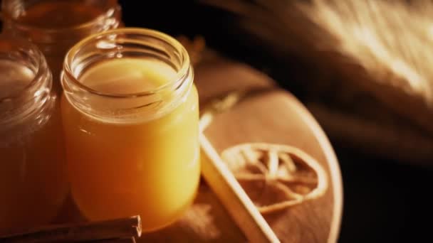 健康的有机蜂蜜在一个有木制蜂蜜切割机顶部观点黑色背景的盘子里 甜甜蜜蜜健康甜点 — 图库视频影像