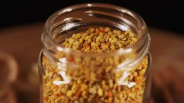Healthy organic honey in a plate with wooden honey dipper top view on black background. Sweet honey healthy dessert Close up