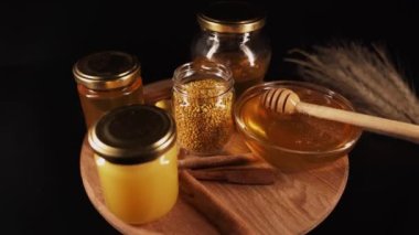 Healthy organic honey in a plate with wooden honey dipper top view on black background. Sweet honey healthy dessert Close up