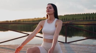 Young woman practicing yoga on the nature at sunset. active meditation a relax concept