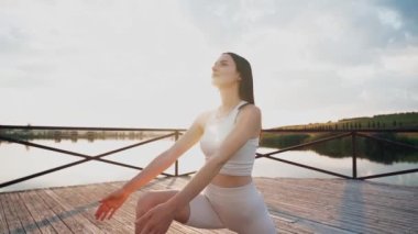 Young woman practicing yoga on the nature at sunset. active meditation a relax concept