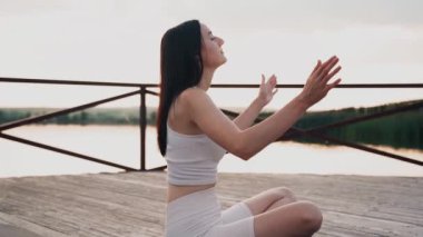 Young woman practicing yoga on the nature at sunset. active meditation a relax concept